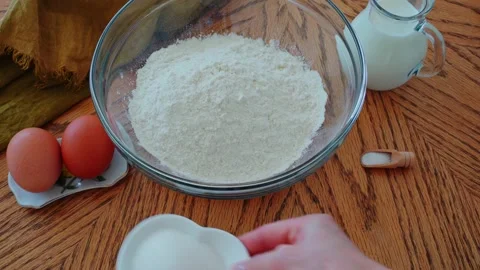 Ingredients for baking are put on the table by a beautiful Caucasian female hand Stock Footage 202274752