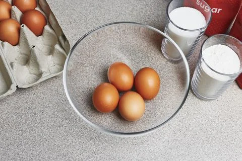 Ingredients for baking cake on a table. Cooking set. Open box with tinted bro Stock Photos