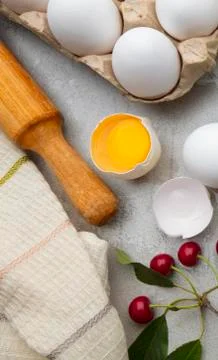 Ingredients baking flour eggs rolling pin berries kitchen textiles on gray Stock Photos