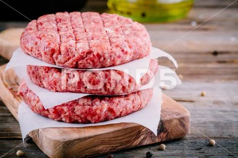 Ingredients for burgers: raw minced beef cutlets Stock Photos
