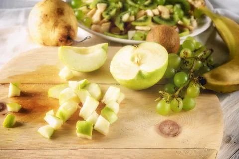 Ingredients for fruit salad. Cutting apple Stock Photos