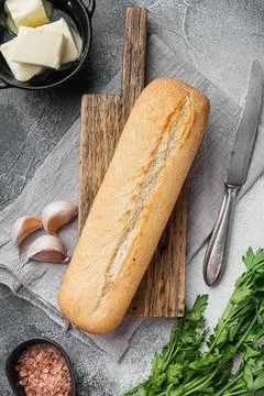Ingredients for Garlic and gerbs bread Baguette, on gray stone table backgrou Stock Photos