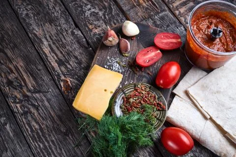 Ingredients for pizza. flat thin bread, tomatoes, garlic, herbs and spices and Stock Photos