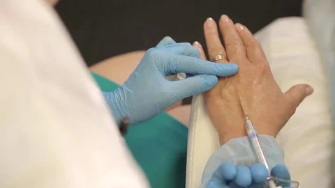 Injection Botox Needle Syringe under the Woman Hand Skin, tightening Procedure Stock-Footage 78726542