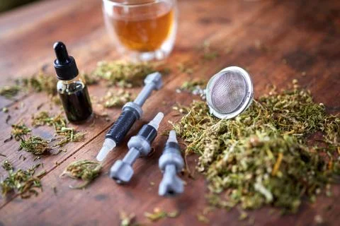 Injection of CBD oil, CBD paste, dried marijuana leaves on wooden background. Stock Photos
