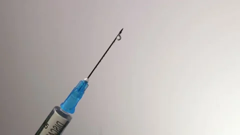Injection drops are dripped from the needle of the syringe Stock Footage 146633329