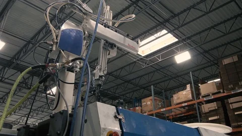 Injection molding machine with robotic arm in American manufacturing factory Stock Footage 129979840