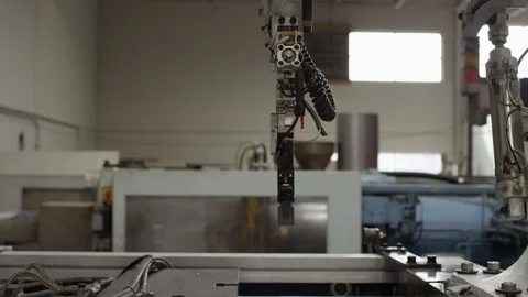 Injection molding machine with robotic arm in American manufacturing factory Stock Footage 129987635