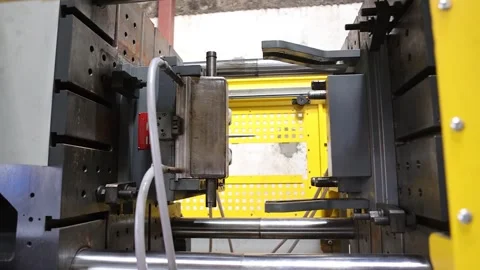 An injection molding machine from which plastic items are made from molds Stock Footage 251634784