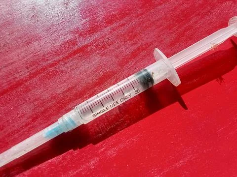 Injection tool with a red background. Stockfoto's