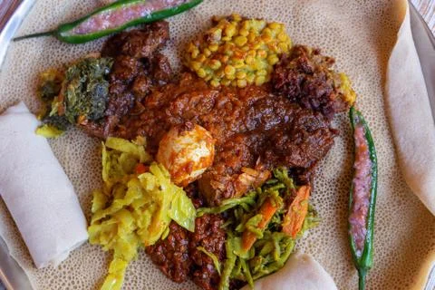 Injera served with Chicken and egg Doro Wat, berbere, vegetables and lentils. Stock Photos
