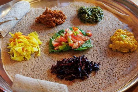 Injera served with vegetables and lentils. Stock Photos