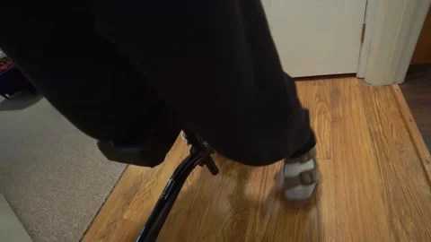 An injured man using a knee scooter while recovering at home Stock Footage 297210376