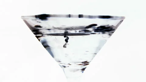 Ink drops fall into a glass beaker with water and slowly sink to the bottom. Stock Footage 112666895