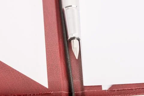 Ink pen on an open leather folder with blank white papers Stock Photos