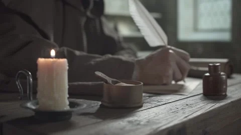Ink sander next to a candle against a blurred background of a monk  writing Stock Footage 340502570