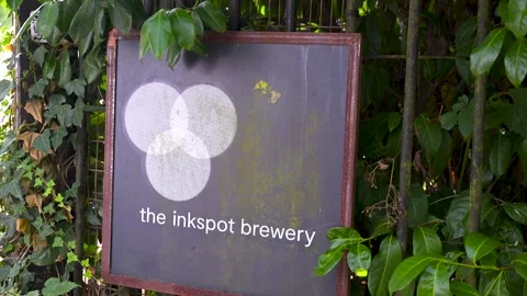 The Inkspot Brewery Sign Framed by Dense Green Foliage Stock Footage 340320016