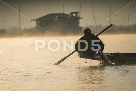 Inle Lake in Myanmar, Traditional Fisherman Crouching at Dawn in Haze Stock Photos