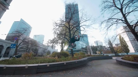 Inline Skater performs beautiful 180 jump on roller blades in modern city Stock Footage 120445719