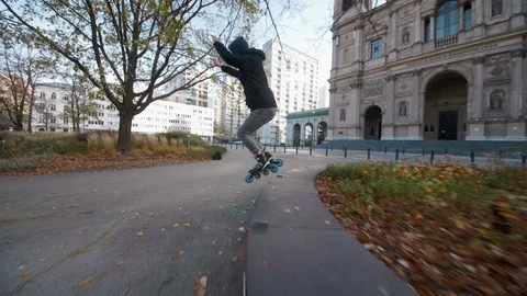 Inline Skater performs beautiful 180 jump on roller blades in city Stock Footage 120445736
