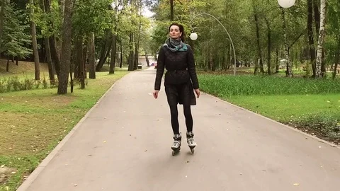 Inline skates. Dark-haired stylish woman moving on roller skates. Slow motion HD Video stock 71308787