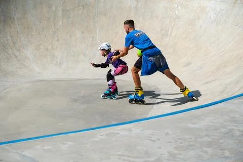Inline Skating Coach Assisting Young Girl During Training Stock Photos