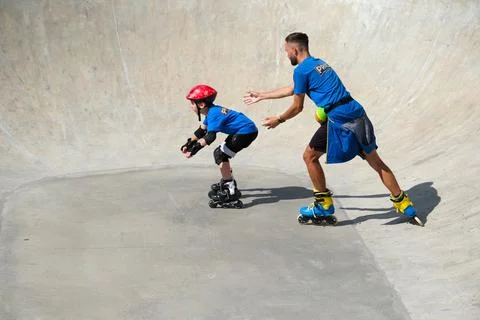 Inline Skating Coach Assisting Young Skater in Skate Bowl Stock Photos