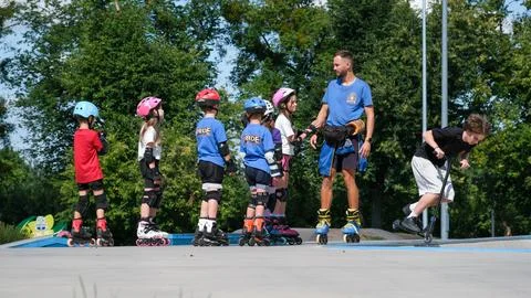 Inline Skating Coach Instructing Children at Outdoor Skatepark Stock Photos