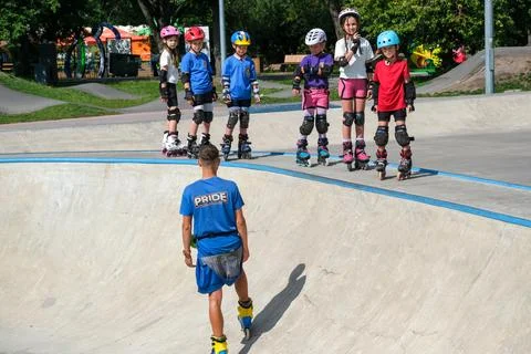 Inline Skating Coach Instructing Children at Skatepark Stock Photos