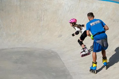 Inline Skating Coach Supervising Young Girl at Skatepark Stock Photos