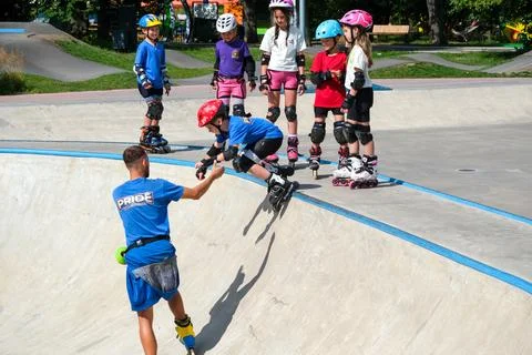 Inline Skating Coach Teaching Children at Outdoor Skatepark Stock Photos