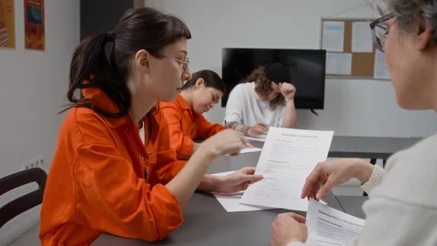 Inmate Asking Questions and Pointing at Print with Teacher Helping Stock Footage 328996038