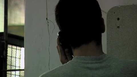 Inmate Making a Phone Call Inside Prison Corridor, Detention Facility - 4K Stock Footage 324989564