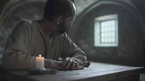 Inmate rubbing hand, staring ahead and turning head toward window inside cell 스톡 동영상 340823016