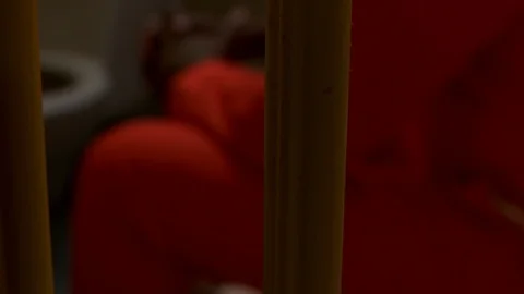 Inmate sits on edge of cot. Vídeo Stock 106413420