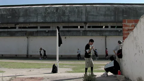 Inmates Playing Soccer and Drinking Mate in Olmos Prison Courtyard - 4K Stock Footage 277918203