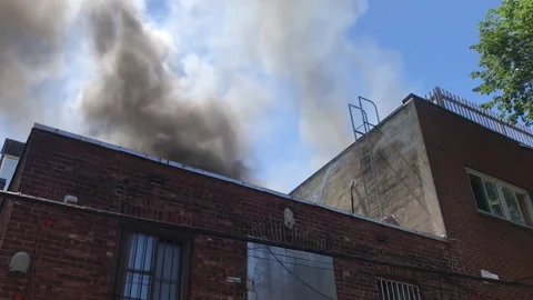 Inner city rooftop fire discovered by neighbors Stock Footage 169442909