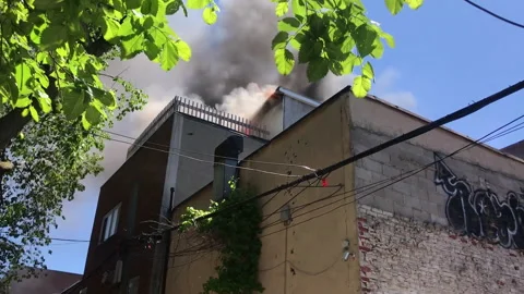 Inner city rooftop fire, flames, smoke Stock Footage 169458100