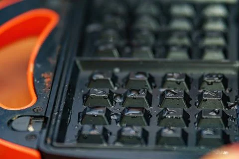 Inner surface of a waffle maker, adorned with glistening drops of oil. It sym Stock Photos