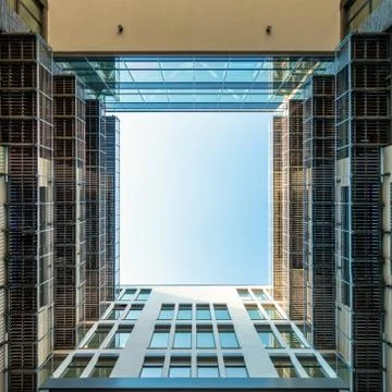 Inner yard of modern office building looking upwards through square opening i Stock Photos