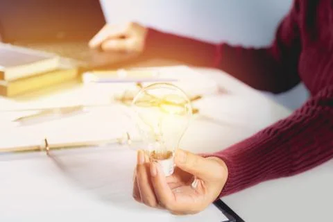 Innovation or creative concept of hand hold a light bulb with laptop. Stock Photos