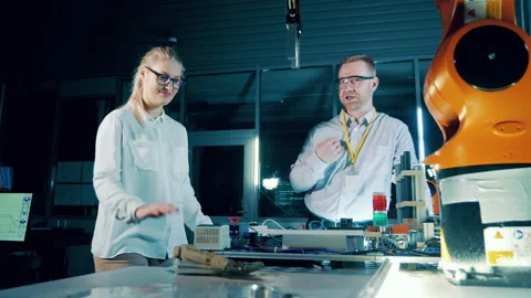 Innovation technology concept. Robotics specialists are observing robotic arm. Stock Footage 240320272