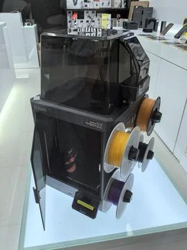 Innovative 3D printer with vibrant filament spools displayed in high-tech sto Stock Photos