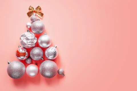 Innovative Christmas tree made of Christmas ornaments on pink background Stock Photos