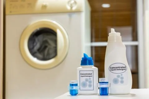 Innovative compact concentrated laundry liquid detergent against washing mach Stock Photos