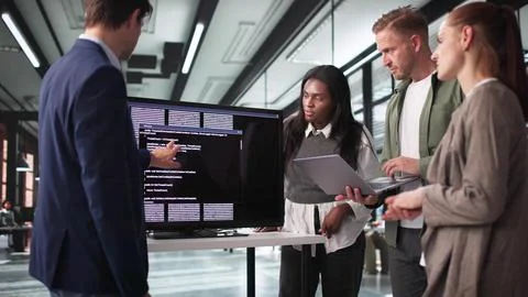 Innovative Developer Guides Team Through Coding Presentation On Big Screen. Stockfoto's