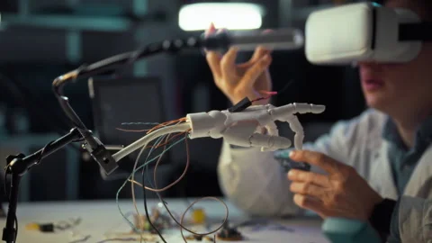 Innovative engineer experimenting with virtual reality and robotic hand tech Stock Footage 331304413