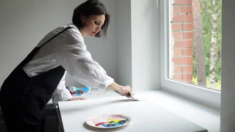 Innovative real female painter using palette knife on big canvas. Stock Footage 197816823