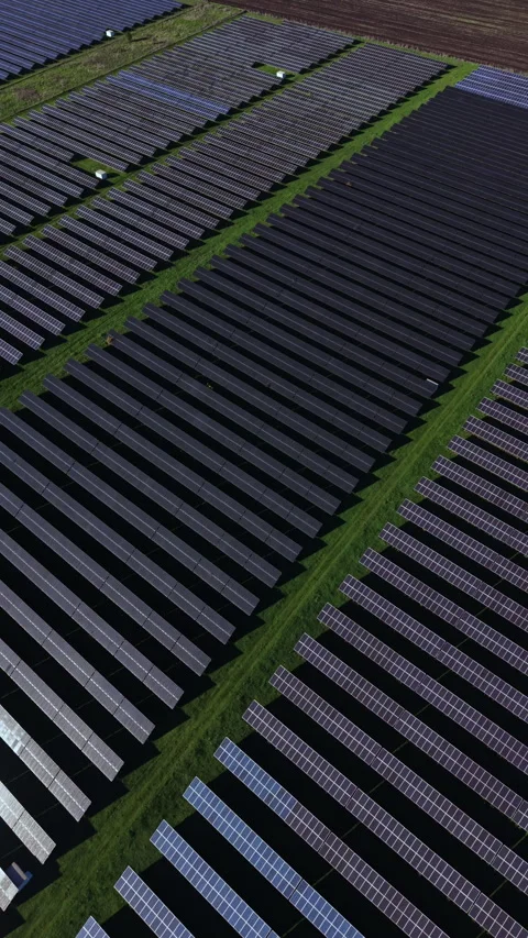 Innovative solar panel array captures sunlight in a vast field during bright Stock Footage 332042394