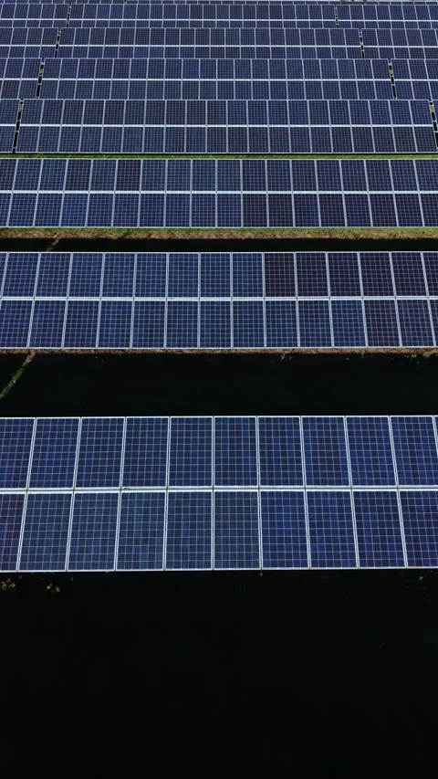 Innovative solar panels capture sunlight in a vast field on a sunny day, Stock Footage 331254314
